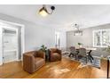 Bright living room featuring hardwood floors, stylish chairs, and modern lighting at 2610 Poplar St, Denver, CO 80207