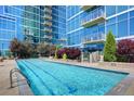 Outdoor pool surrounded by lush landscaping, with modern high-rise building in the background at 1700 Bassett St # 2117, Denver, CO 80202