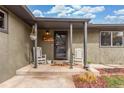 Inviting front porch featuring two rocking chairs and a hanging flower basket for curb appeal at 5761 W 50Th Ave, Denver, CO 80212