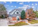 Charming two-story home featuring a manicured lawn, decorative rock beds, and mature trees at 8 Mountain High Ct, Littleton, CO 80127