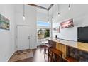 Bright living room features high ceilings, a custom bar, wood floors, and large windows with plenty of natural light at 10512 Hyacinth St, Highlands Ranch, CO 80129