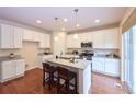 Bright kitchen with white cabinets, stainless steel appliances, and central island with barstool seating at 13424 W 64Th Pl, Arvada, CO 80004