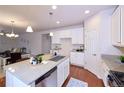 Modern kitchen with granite counters, stainless steel appliances, white cabinets, and an island with a sink at 13424 W 64Th Pl, Arvada, CO 80004