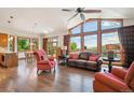 Open-concept living room with vaulted ceilings, hardwood floors, and large windows framing scenic views at 16442 Rocky Point Ln, Morrison, CO 80465