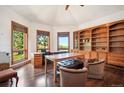 Bright office with hardwood floors, built-in bookshelves, and large windows offering natural light and views at 16442 Rocky Point Ln, Morrison, CO 80465