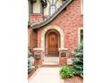 Inviting front entrance featuring an arched stone entryway, wooden door, and decorative iron gate at 958 S Columbine St, Denver, CO 80209