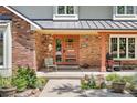 Inviting front porch with brick accents and a modern front door, perfect for enjoying the outdoors at 1579 W Costilla Pl, Littleton, CO 80120