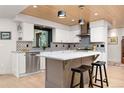 Modern kitchen featuring white cabinets, sleek stainless steel appliances, and a central island with seating at 1579 W Costilla Pl, Littleton, CO 80120