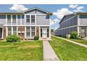 Close up of townhome front entrance with walkway and manicured lawn on a sunny day at 12020 E Canal Dr, Aurora, CO 80011