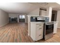 Updated kitchen with stainless steel oven, white cabinetry, and view of living room at 7255 E Quincy Ave # 205, Denver, CO 80237