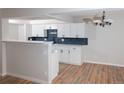 Bright kitchen with white cabinets, dark hardware, and an eat-in breakfast bar at 7255 E Quincy Ave # 205, Denver, CO 80237