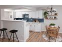Charming kitchen and breakfast nook boasts white cabinets, modern backsplash, and seating for a cozy dining experience at 7255 E Quincy Ave # 205, Denver, CO 80237