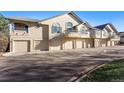 Townhome garages with large driveways and stucco exteriors at 8671 E Dry Creek Rd # 721, Englewood, CO 80112