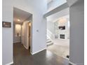 Hallway featuring hardwood flooring, leading to staircase and rooms with neutral paint and natural light at 17037 E Wiley Pl, Parker, CO 80134