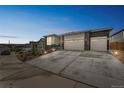 View of the home's three-car garage and wide driveway, complemented by landscaped front yard at 1148 Sunlit Dr, Castle Rock, CO 80109