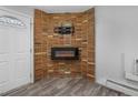 Corner fireplace with a modern electric insert, brick facade, and wall-mounted TV hookup at 2190 S Holly St # 207, Denver, CO 80222