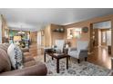 Spacious living room featuring hardwood floors and natural light extending into the kitchen and dining areas at 2085 E 127Th Pl, Thornton, CO 80241