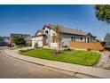 Well-manicured lawn and garden beds complement the gray exterior of this suburban home at 9451 Desert Willow Trl, Highlands Ranch, CO 80129