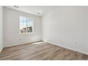 Bright, empty bedroom featuring a large window and light, plank-style flooring at 9672 Cathay St, Commerce City, CO 80022