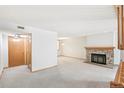Spacious living room with a stone fireplace, neutral carpet, and ample natural light at 1350 S Idalia St # G, Aurora, CO 80017