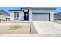 Modern home exterior featuring stone accents, a gray garage door, and a concrete driveway at 22097 E Rockinghorse Pkwy, Aurora, CO 80016