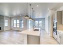 Open kitchen and living area with island, modern appliances, and lots of natural light at 22097 E Rockinghorse Pkwy, Aurora, CO 80016