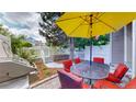 Outdoor patio featuring a dining set with red cushions and a yellow umbrella, perfect for entertaining guests at 2560 Concord Cir, Lafayette, CO 80026