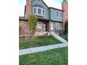 Two-story townhome with brick and green siding, plus a neat lawn at 17437 E Rice Cir # B, Aurora, CO 80015