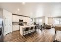 Open-concept kitchen with a large island, stainless steel appliances and a seamless flow into the dining and living areas at 9227 Salida St, Commerce City, CO 80022