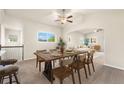 Open concept dining room with a wooden table, chairs, and large windows bringing in natural light at 6202 Kilmer Loop # 202, Golden, CO 80403