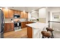 Modern kitchen with stainless steel appliances, wood cabinets, breakfast bar, and ample counter space at 6202 Kilmer Loop # 202, Golden, CO 80403