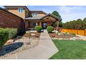 Inviting front entrance featuring manicured landscaping, a covered porch, and a stone walkway leading to the front door at 5925 Zinnia Ct, Arvada, CO 80004
