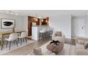 Stylish living room with contemporary furniture and a dining area with a bar and kitchen in the background at 480 S Marion Pkwy # 802, Denver, CO 80209