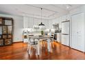Kitchen featuring a dining table, white cabinets, modern appliances, and hardwood floors at 3465 S Poplar St # 506, Denver, CO 80224