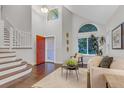 Bright foyer with high ceilings, a striking orange front door, and an open staircase leading to the upper level at 4112 Brandon Ave, Broomfield, CO 80020