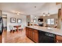 Open concept living spaces with hardwood floors include kitchen, dining, and living room at 1044 Rockhurst Dr # 208, Highlands Ranch, CO 80129