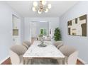 Elegant dining room featuring modern lighting, marble table, and stylish decor at 19410 E Ithaca Pl, Aurora, CO 80013