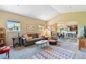 Bright living room featuring a sofa, armchairs, vaulted ceiling, and seamless flow to the kitchen at 6292 Kilmer Loop # 201, Golden, CO 80403
