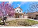 Charming two-story home featuring a welcoming front porch and beautiful, mature landscaping at 10933 E 115Th Pl, Commerce City, CO 80640