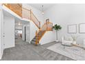 Bright foyer with wood staircase, neutral walls, gray carpet, and high ceilings at 10933 E 115Th Pl, Commerce City, CO 80640
