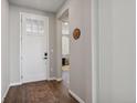 Bright foyer with a patterned rug on wood floors leading into a well-lit home at 1925 Peregrine Dr, Brighton, CO 80601