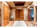 Elegant foyer with double doors, light wood floors, and a decorative ceiling feature at 4691 Bandera Pl, Parker, CO 80134