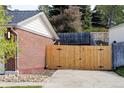 Wooden gate in a private fenced-in backyard next to a brick home offers secure access and enhances the outdoor space at 9380 Raleigh Ct, Westminster, CO 80031