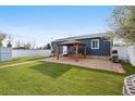 Expansive backyard featuring a covered patio, lush artificial turf, white fencing, and a built-in grill perfect for entertaining at 1498 S Perry St, Denver, CO 80219