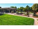Landscaped backyard features a large grassy area, custom pergola, water feature and fire pit, plus outdoor seating at 3299 S Newcombe St, Lakewood, CO 80227