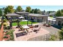 Landscaped backyard features a well-manicured lawn, pergola, a fire pit, and an outdoor seating area at 3299 S Newcombe St, Lakewood, CO 80227