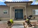 Charming front porch with a blue front door, seating, and decorative plants at 3299 S Newcombe St, Lakewood, CO 80227