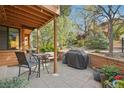 Outdoor patio area with seating, brick surround, and mature trees at 9400 E Iliff Ave # 181, Denver, CO 80231