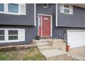 Inviting front entrance with a red door, landscaping and a small porch leading to the home at 103 Aurelia St, Palmer Lake, CO 80133