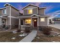 Two-story townhome with a red door and walkway at 6108 Summit Peak Ct # 102, Erie, CO 80516